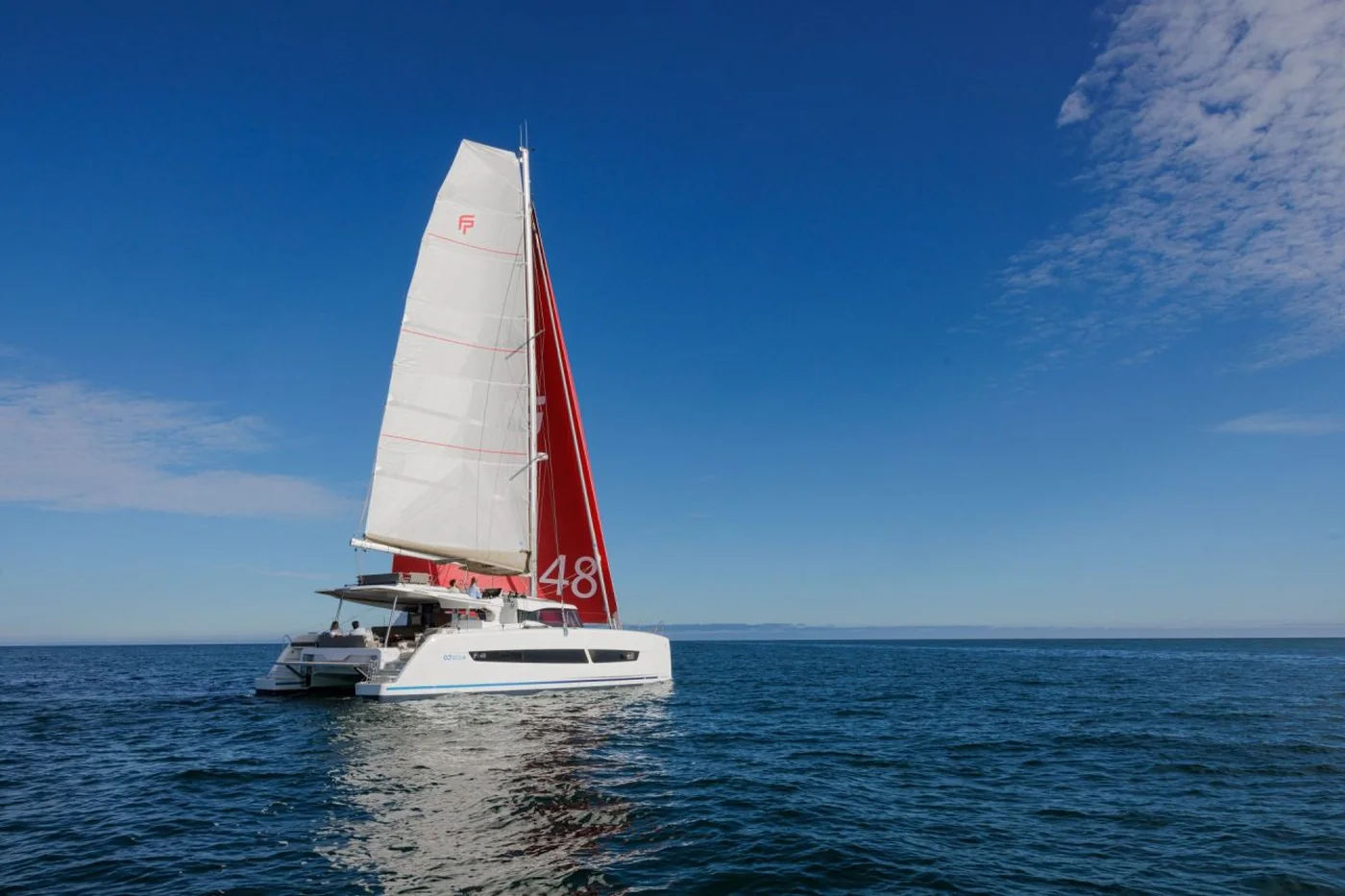 The Fountaine Pajot FP48 catamaran under sail with a red mainsail