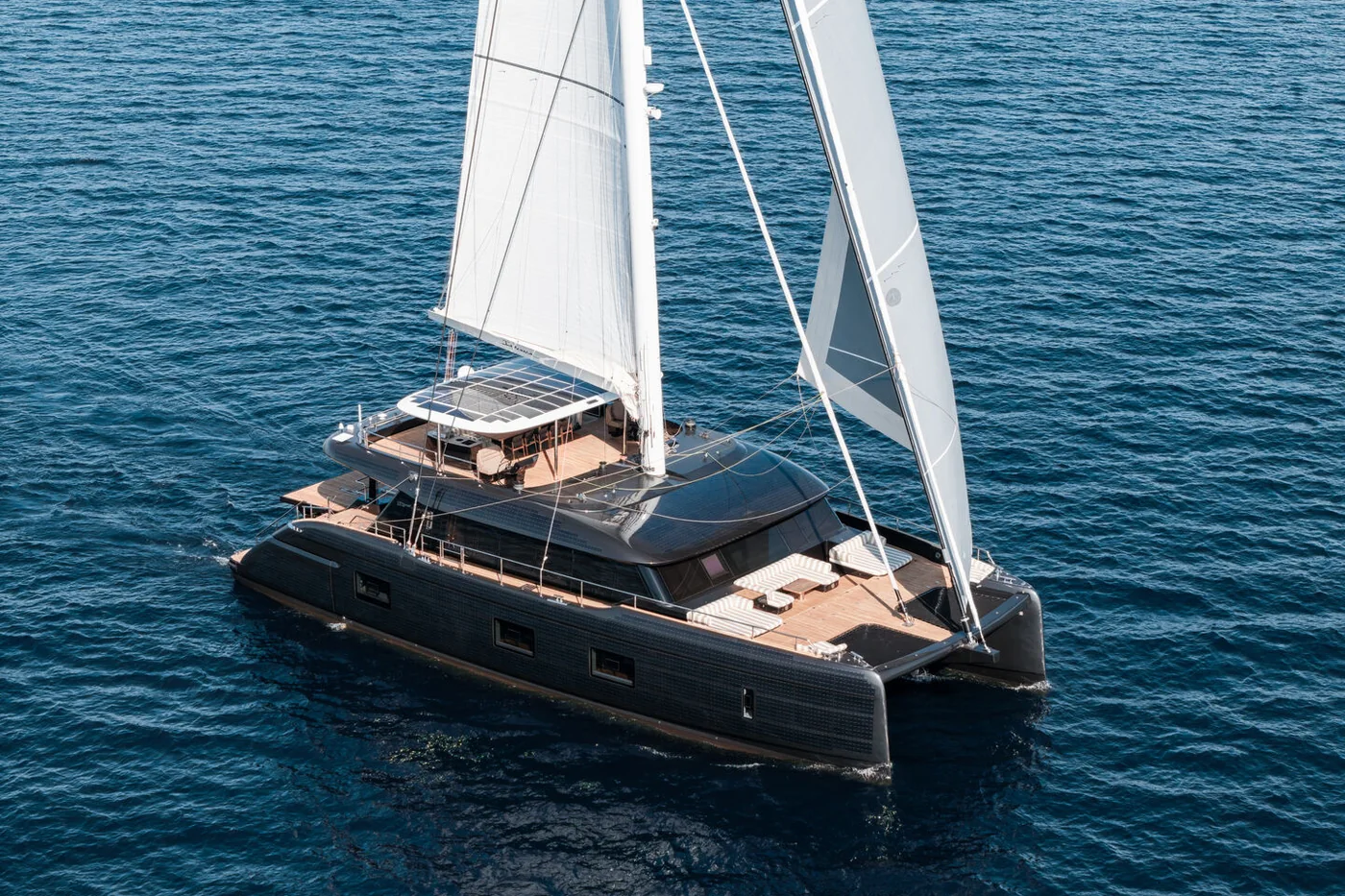 The fully electric Sunreef 100 Eco sailing catamaran with its dark hull and solar panels