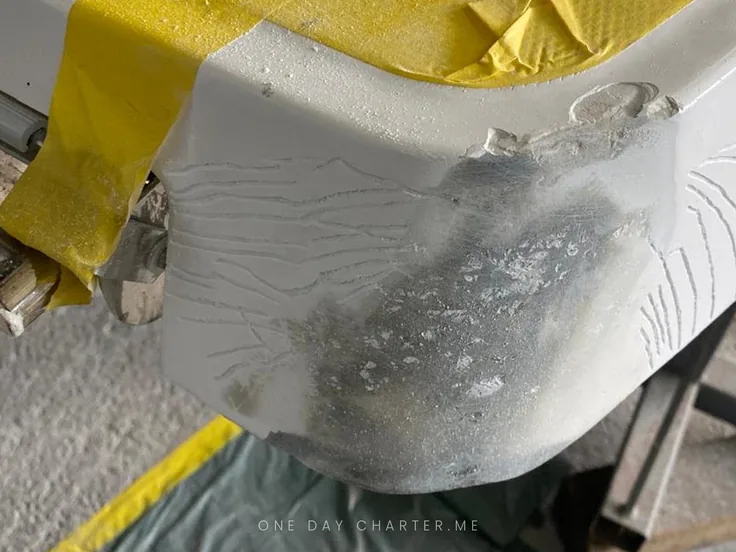The corner of a swim platform with gelcoat damage before the repair